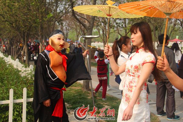 一个猪八戒造型的演员，凝视游园的旗袍美女